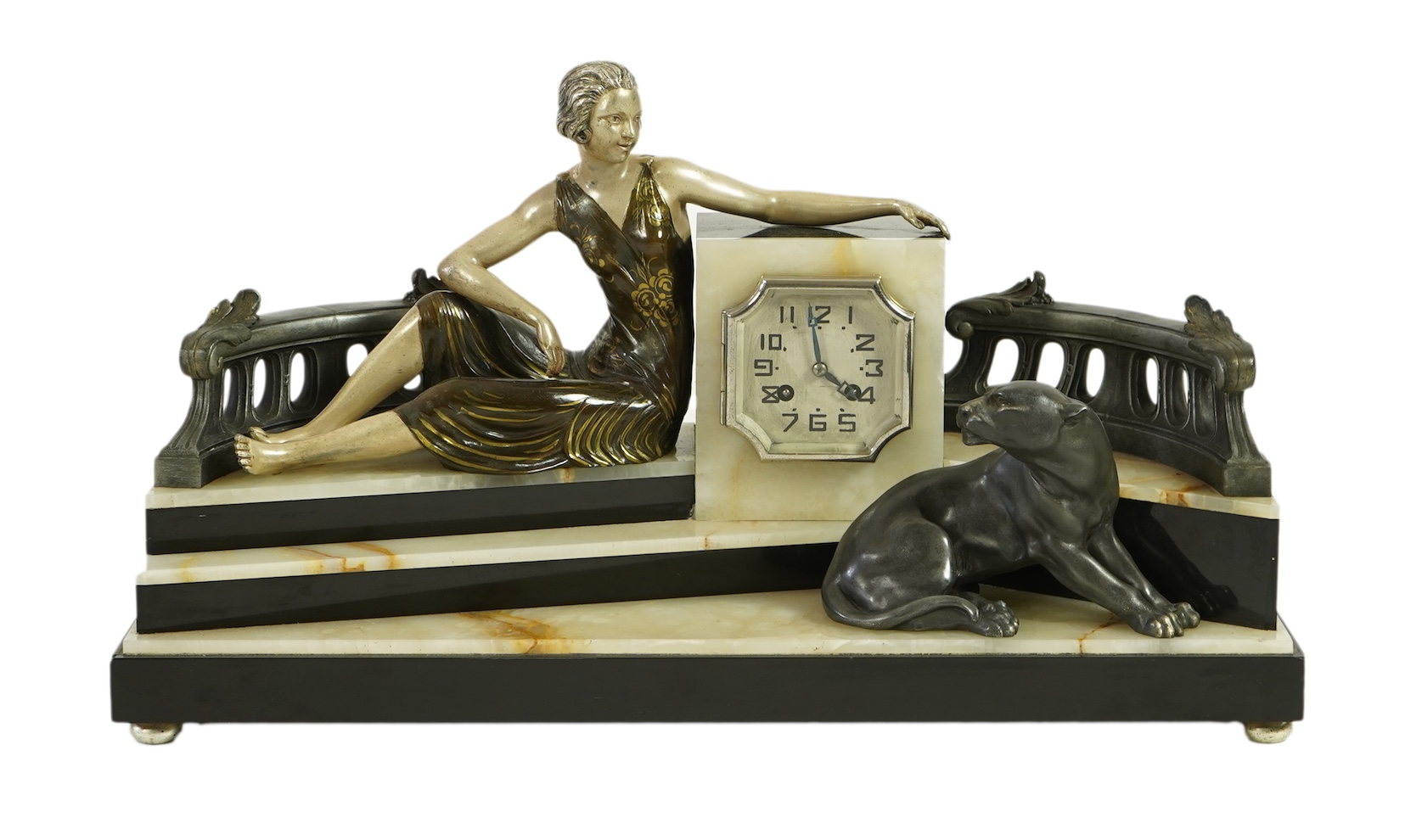 A French Art Deco onyx and patinated spelter clock surmounted with a lady and a black panther on a staircase